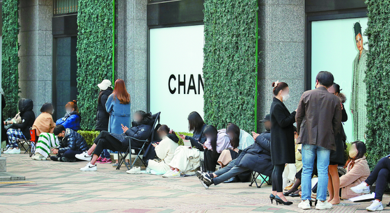 값 비싼 상품을 사기 위해 줄서 있는 모습을 나타내고 있다. 스놉 효과를 잘 나타내고 있다